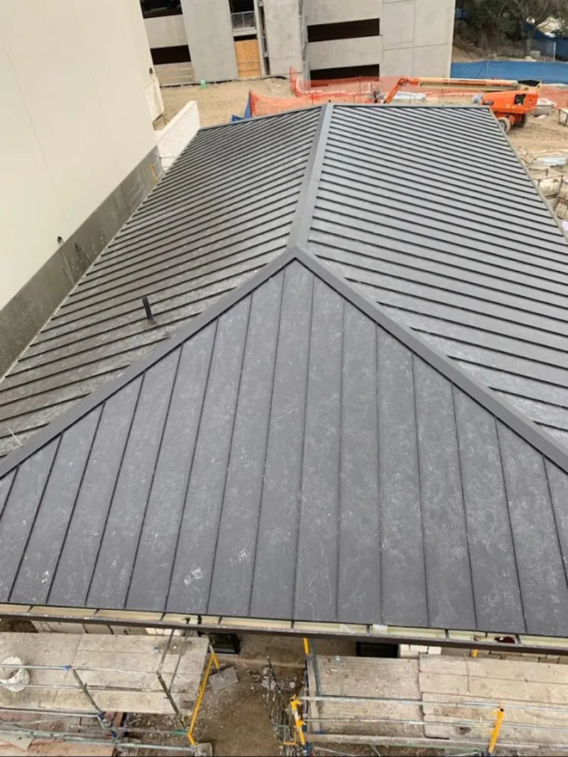 Commercial metal roof construction with crane equipment in Napoleon